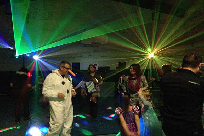 School Laser Light Show, Hamilton DJ, Family Dance with multi colored beams coming from the light show and wide green beams coming from the laser light show. Taken in Hamilton Ontario.